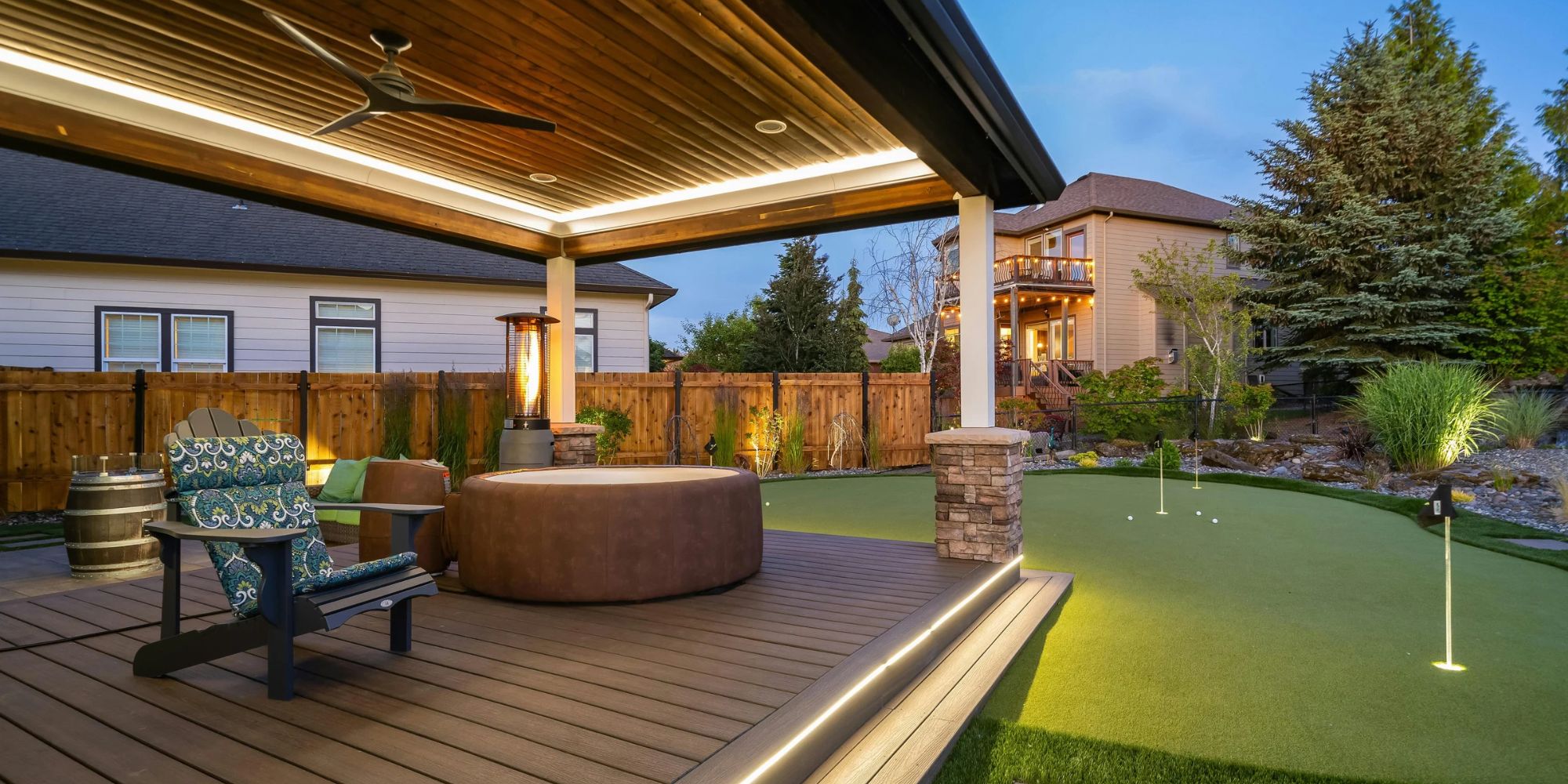 Covered patio with hot tub overlooking the yard